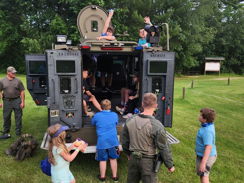 Campers visiting with law enforcement officers and their vehicle