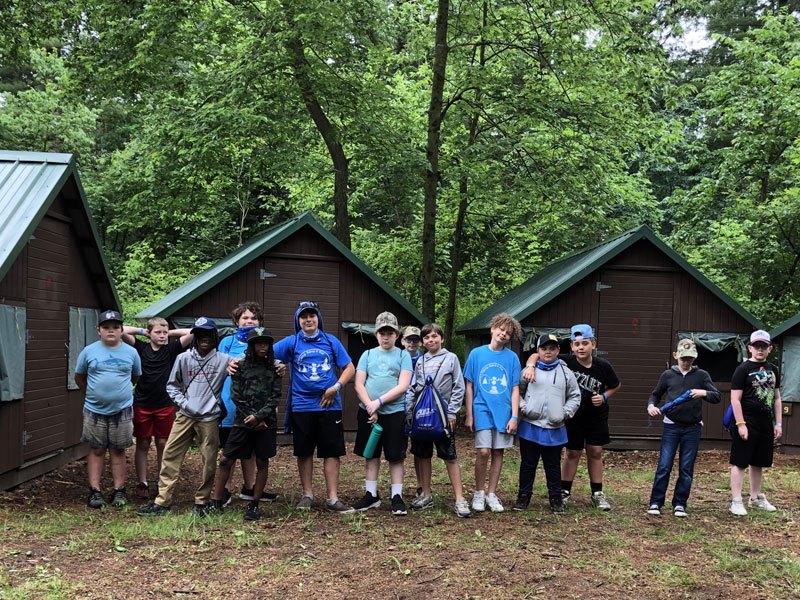 Campers and staff in front of the cabins