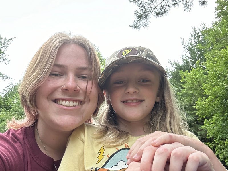 A counselor and a camper taking a selfie