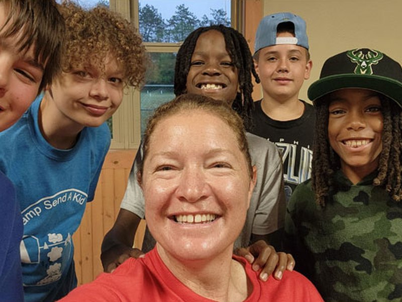 A counselor and campers taking a group selfie